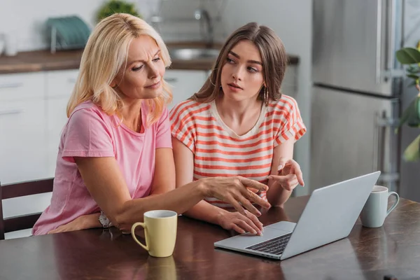 Mother Daughter Pointing Fingers Laptop While Sitting Kitchen Table — Stock Photo, Image