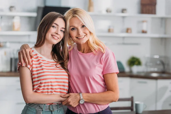 Happy Mother Daughter Hugging Holding Hands While Smiling Camera Kitchen — Stock Photo, Image