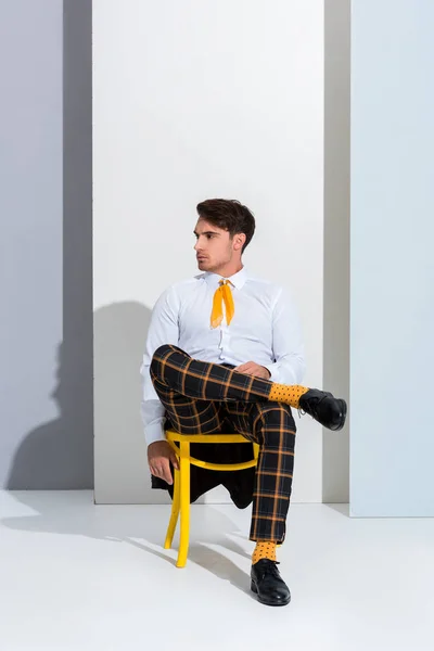 Handsome Man Posing While Sitting Yellow Chair White Grey — Stock Photo, Image