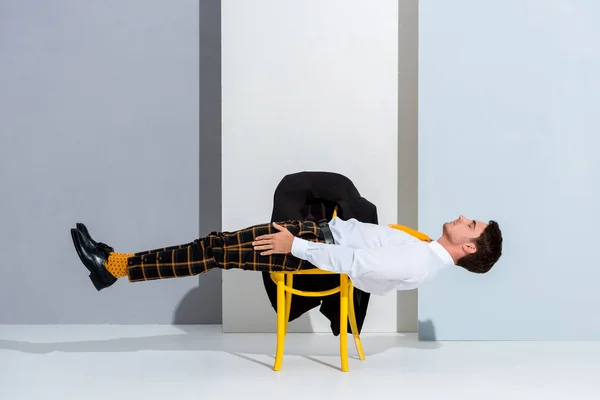 Man Posing While Lying Yellow Chair White Grey — Stock Photo, Image