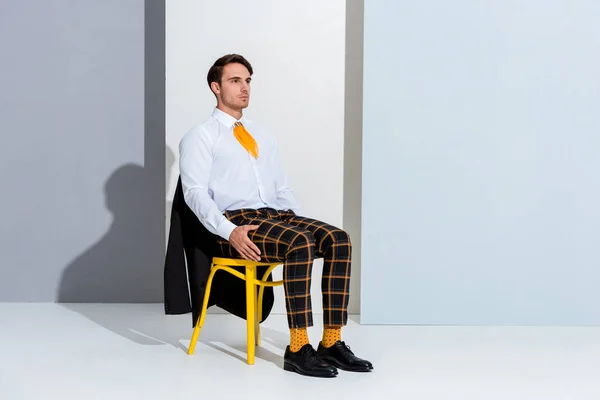 Jovem Sentado Cadeira Amarela Branco Cinza — Fotografia de Stock