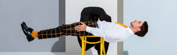 Tiro Panorâmico Homem Calças Xadrez Deitado Cadeira Amarela Branco Cinza — Fotografia de Stock