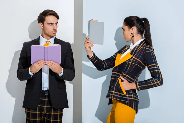 Hombre Sosteniendo Libro Cerca Elegante Chica Posando Mientras Lee Blanco — Foto de Stock