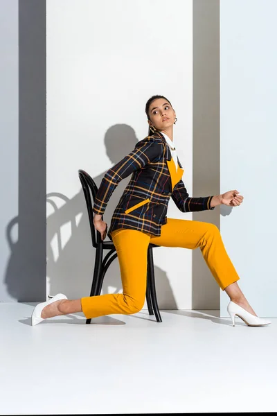 Attractive Girl Sitting Chair Looking Away White Grey — Stock Photo, Image