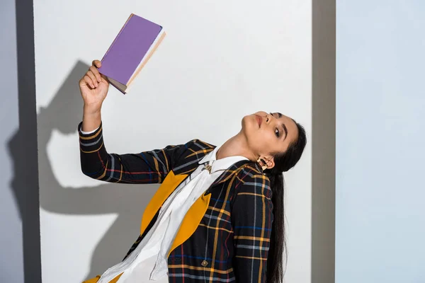 灰色と白の紫色の本を持っている魅力的な女性 — ストック写真