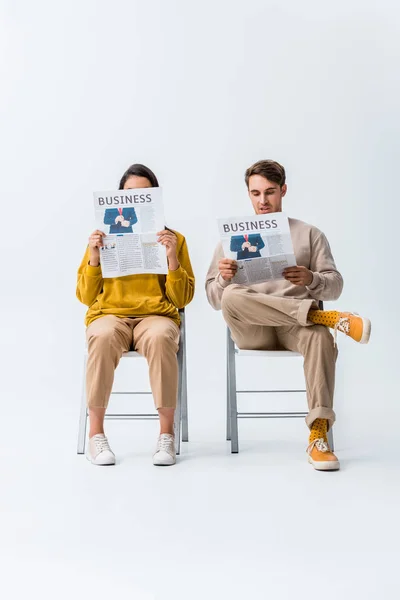 Junge Frau Und Mann Sitzen Auf Stühlen Und Lesen Wirtschaftszeitungen — Stockfoto