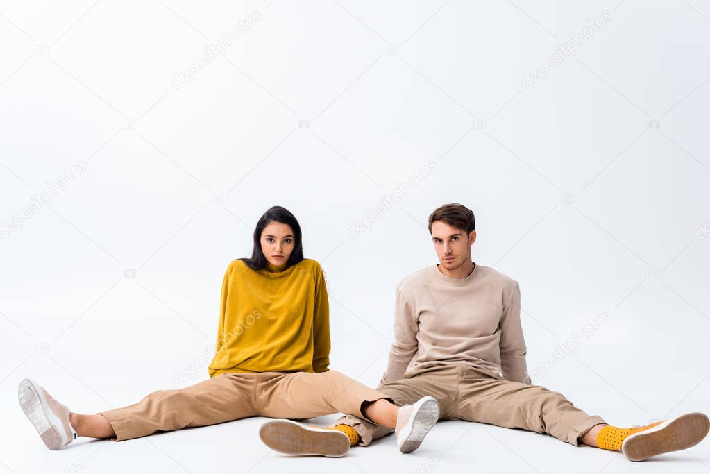 handsome man and woman sitting on white 