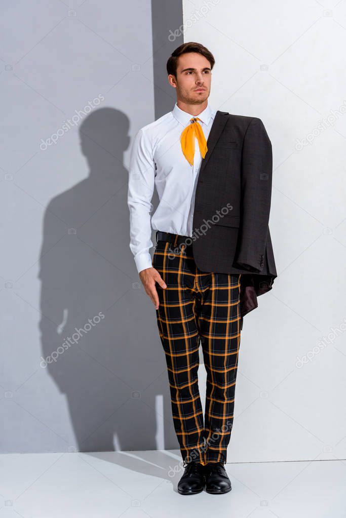 handsome man in plaid trousers standing on white and grey 