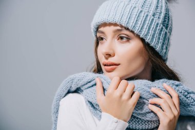 beautiful tender girl posing in blue knitted hat and scarf, isolated on grey clipart