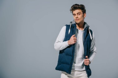 Güz yelekli moda bir adam, gri renkte izole edilmiş.