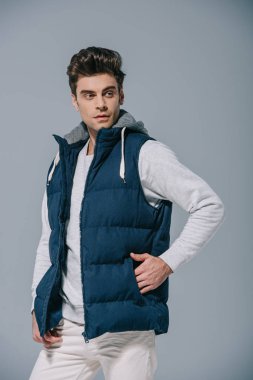 Yakışıklı, modaya uygun, yelekli, gri elbiseli bir adam.