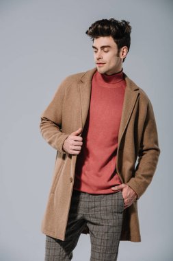 Gri renkte izole edilmiş bej rengi sonbahar ceketli moda bir adam.