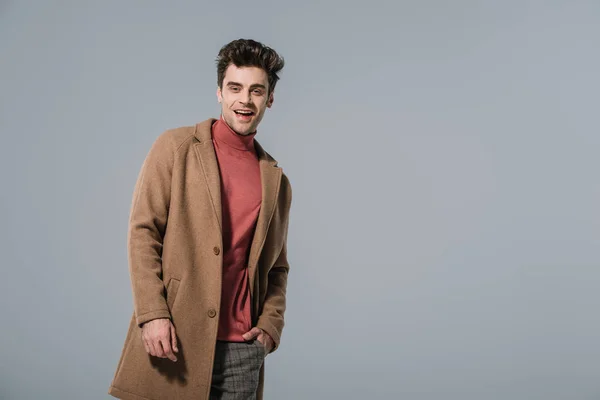 Alla Moda Uomo Sorridente Posa Cappotto Beige Isolato Grigio — Foto Stock