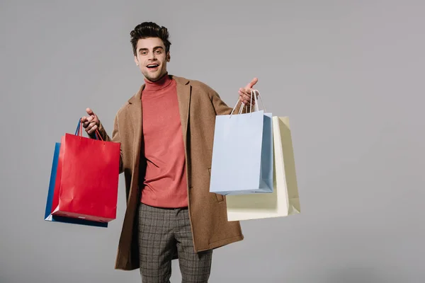 Fröhlich Stylischer Mann Beigen Mantel Mit Einkaufstaschen Isoliert Auf Grau — Stockfoto