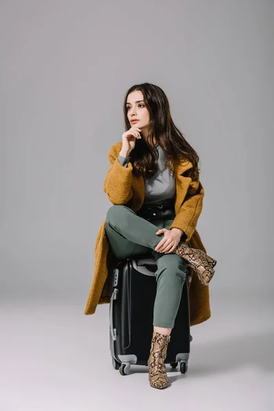 Beautiful Pensive Woman Beige Coat Sitting Travel Bag Grey — Stock Photo, Image