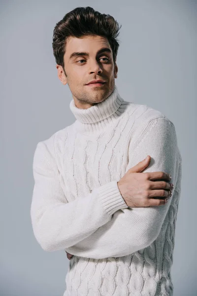 handsome man posing in knitted sweater, isolated on grey