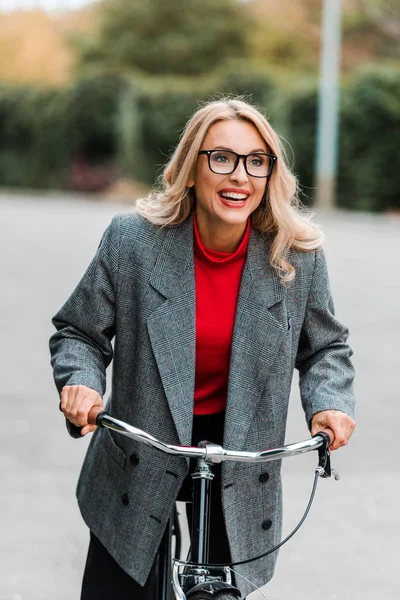 Attractive Businesswoman Coat Glasses Smiling Riding Bike — Stock Photo, Image