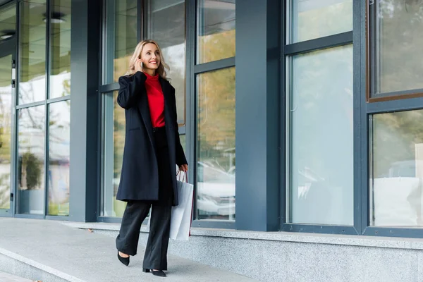 Atractiva Mujer Negocios Hablando Teléfono Inteligente Sosteniendo Bolsa Compras — Foto de Stock