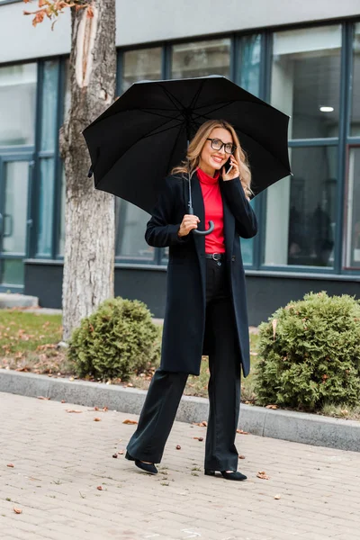 Attractive Businesswoman Coat Glasses Holding Black Umbrella Talking Smartphone — Stock Photo, Image