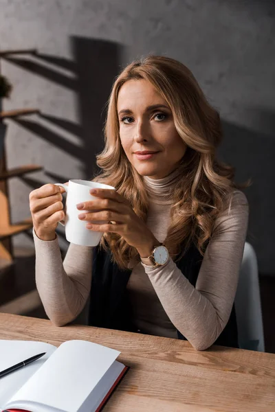 Atraktivní Blond Podnikatelka Sedí Stolu Drží Pohár — Stock fotografie