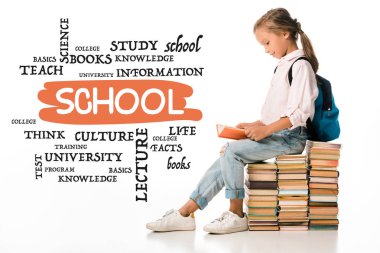 Neşeli okul çocuğu kitapların üzerinde oturuyor ve beyaz harflerin yanında kitap okuyor. 