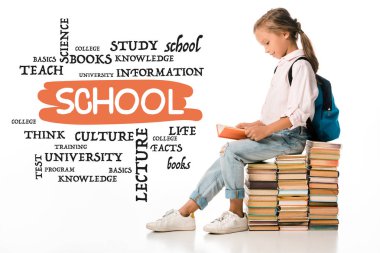 cheerful schoolkid sitting on books and reading near lettering on white  clipart
