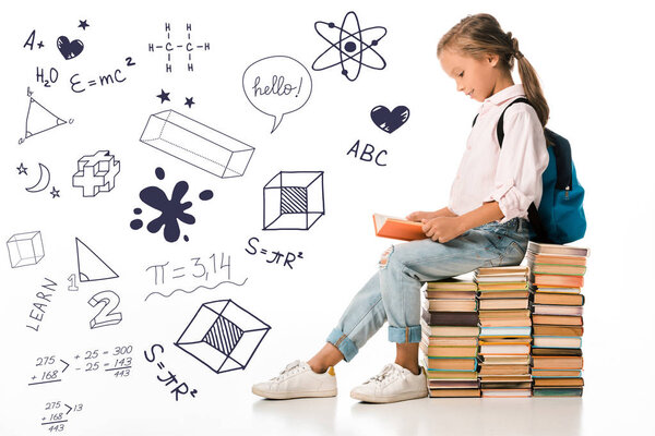 cheerful schoolkid sitting on books and reading near letters and mathematical formulas  on white 