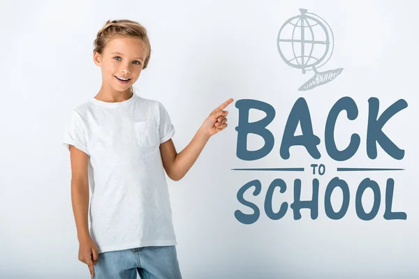 Cheerful Kid Looking Camera Pointing Finger Back School Letters White — Stock Photo, Image