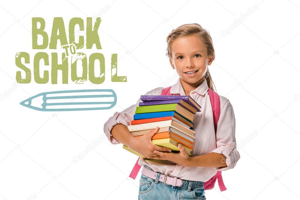 happy schoolkid holding colorful books near back to school letters on white 