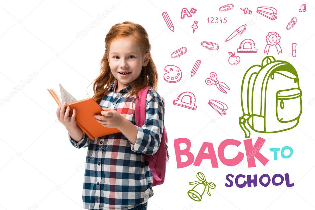 cheerful redhead kid holding orange book near welcome back to school letters isolated on white 