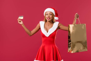 Noel Baba şapkalı ve noel elbiseli Afro-Amerikan kızı elinde kredi kartı ve alışveriş çantası vardı.
