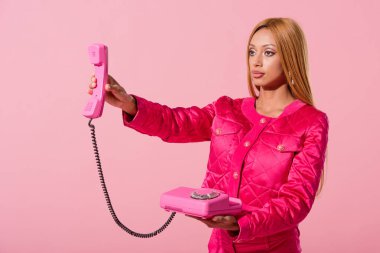 Şık Afro-Amerikan kadın cep telefonunu pembe, moda bebek konseptine izole etmiş.