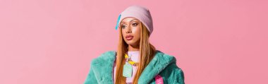 Pembe, moda bebeği konseptinde izole edilmiş etiketli düşünceli, şık Afrikalı Amerikalı kadının panoramik bir fotoğrafı.