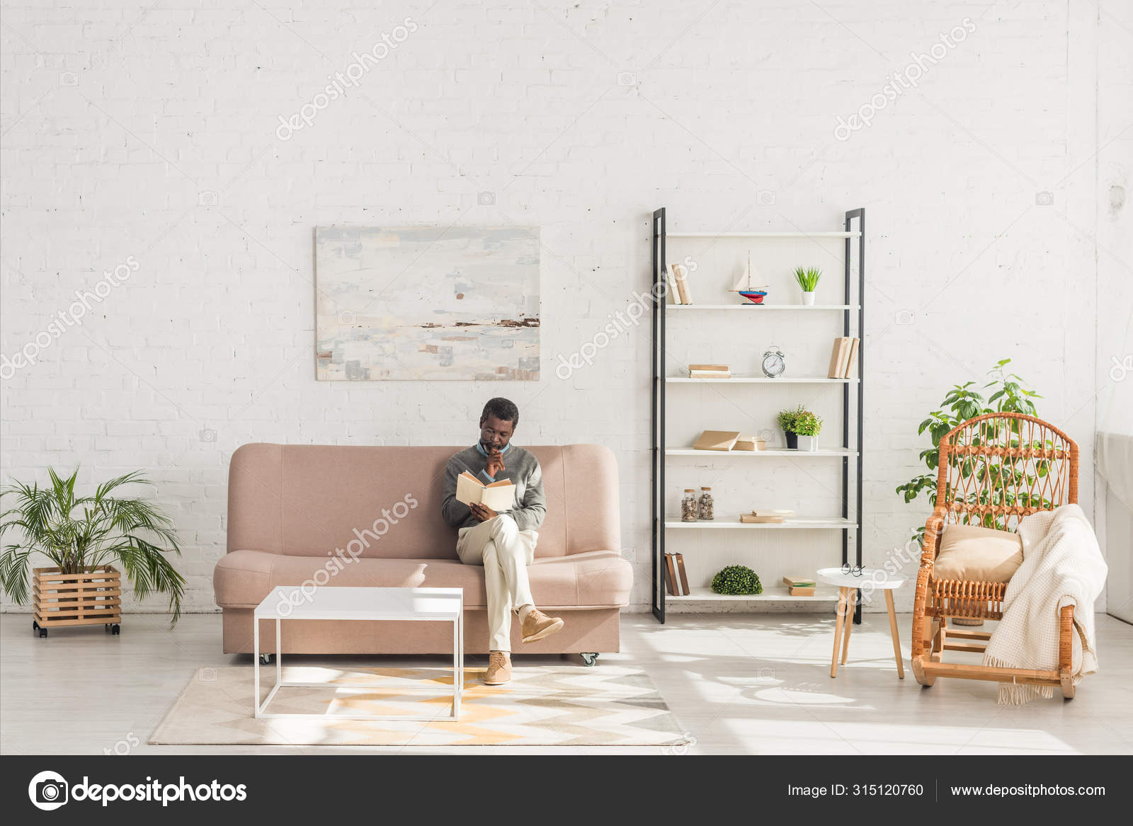 Senior African American Man Reading Book While Sitting Sofa Living Stock Photo