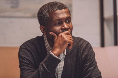 Depresyonda olan Afrikalı Amerikalı bir adam el ele tutuşurken yüzünü çeviriyor.