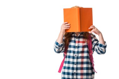 pupil covering face with orange book isolated on white  clipart