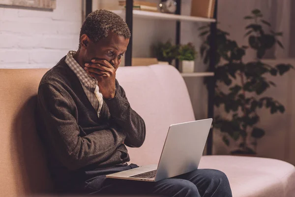 Chateado Afro Americano Homem Sentado Sofá Olhando Para Laptop — Fotografia de Stock