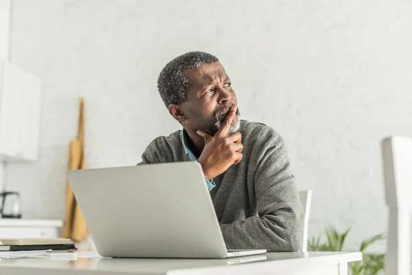 Задумливий Афроамериканський Чоловік Дивлячись Далеко Сидячи Біля Ноутбука — стокове фото