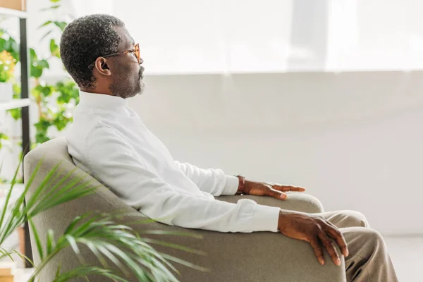 Sénior Hombre Afroamericano Elegante Sentado Sillón Mirando Hacia Otro Lado —  Fotos de Stock