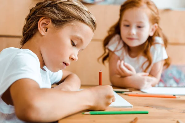 近红头发儿童在纸上画的可爱儿童的选择性焦点 — 图库照片