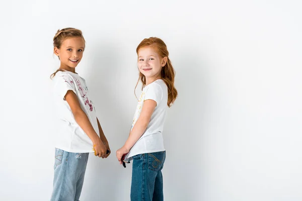 happy kids with paint on t-shirts standing on white