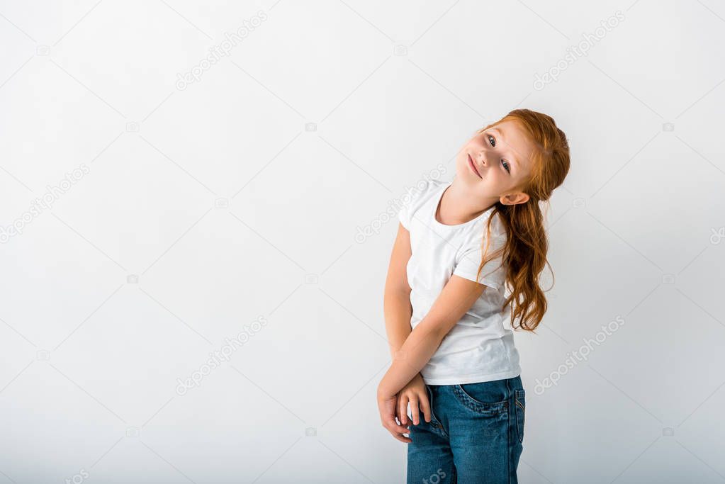 happy redhead kid looking at camera on white 