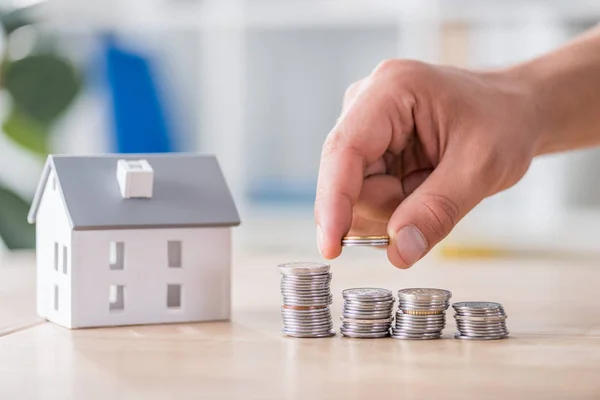 İş adamlarının manken yakınındaki ahşap masaya para istiflemesi kısmen görülebilir