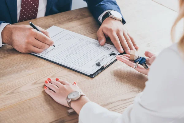 Gedeeltelijk Uitzicht Zakenvrouw Met Huissleutels Buurt Van Man Ondertekening Overeenkomst — Stockfoto