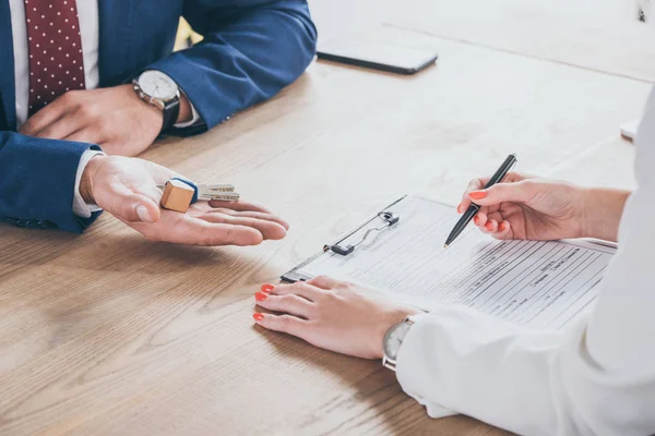 Gedeeltelijke Weergave Van Zakenman Met Huissleutels Buurt Van Man Ondertekening — Stockfoto