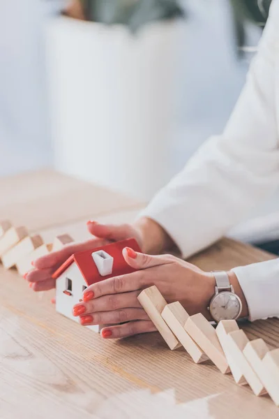 Partial View Businesswoman Protecting House Model Falling Wooden Blocks Hands — Stock Photo, Image