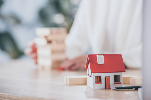 selective focus of house model near risk manager and wooden blocks