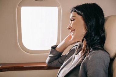 Mutlu iş kadını özel jette müzik dinliyor. 