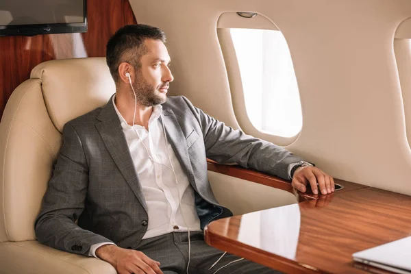 Selective Focus Handsome Businessman Listening Music Looking Airplane Window — Stock Photo, Image