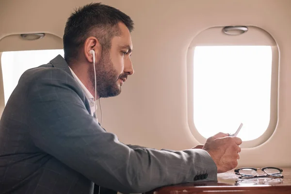 Side View Businessman Earphones Using Smartphone Private Jet — Stock Photo, Image